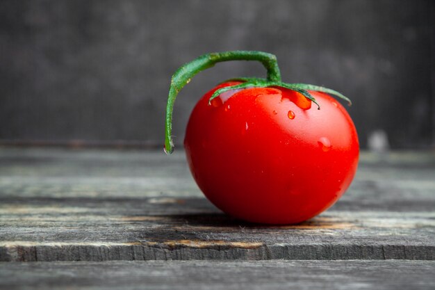 Foto gratuita vista lateral de tomate sobre fondo oscuro de madera y textura. horizontal