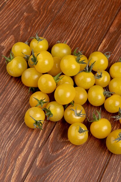 Vista lateral de tomates amarillos sobre superficie de madera