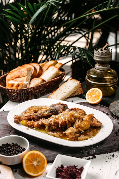 Vista lateral del tradicional buglama azerbaiyano en un plato blanco con cebolla