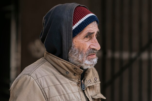 Vista lateral del triste hombre sin hogar barbudo