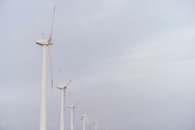 Vista lateral de las turbinas eólicas que generan electricidad con espacio de copia