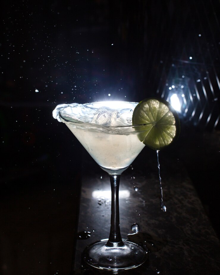 Foto gratuito vista lateral del vaso de martini con rodaja de limón en negro