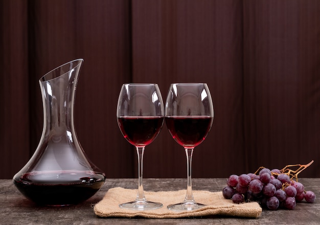 Vista lateral vino tinto en vaso con uva en horizontal