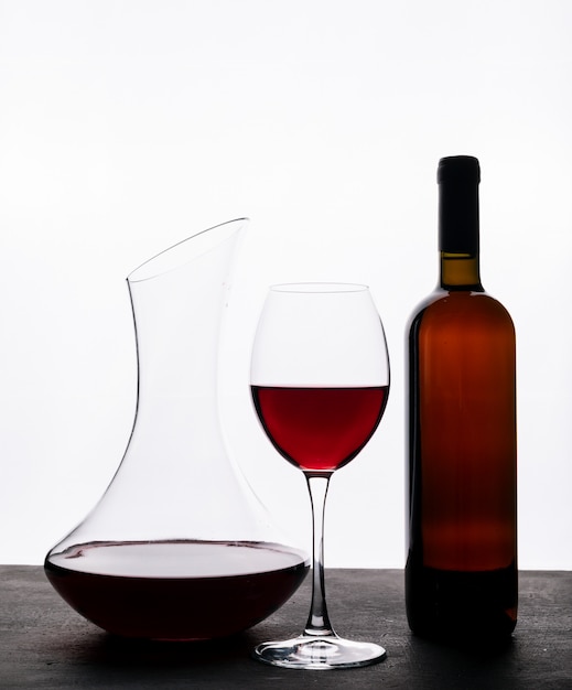 Foto gratuita vista lateral vino tinto con vidrio en blanco vertical