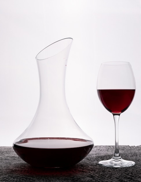 Vista lateral vino tinto con vidrio en blanco vertical