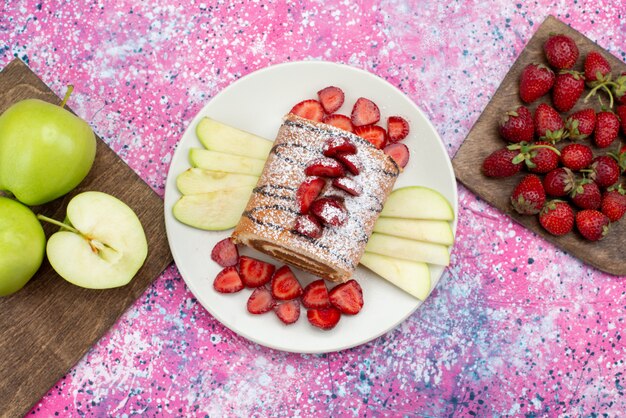 Vista lejana superior rollo de rebanadas de pastel con diferentes frutas dentro de un plato blanco en el piso morado pastel galleta fruta dulce