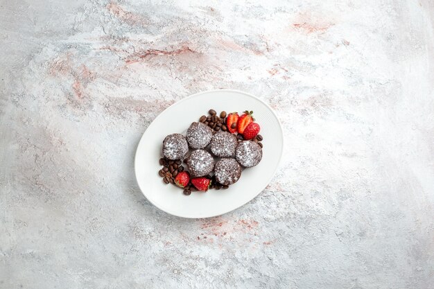 Vista lejana superior sabrosos pasteles de chocolate con fresas y chispas de chocolate en la superficie blanca pastel de galletas hornear azúcar dulce pastel de galletas