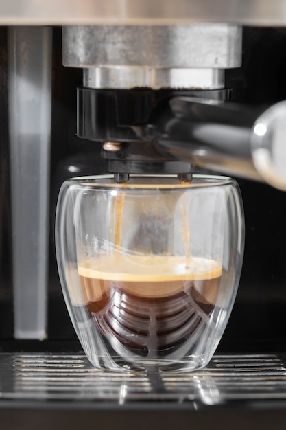 Sirviendo café en una taza desde una cafetera con granos de café Stock  Photo