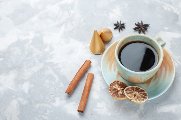 Vista de media taza de té con canela en el escritorio blanco té color caramelo desayuno