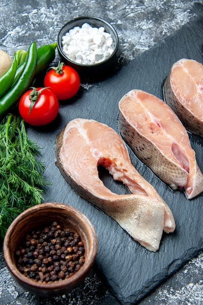 Vista de la mitad inferior rebanadas de pescado crudo en la pizarra en la mesa