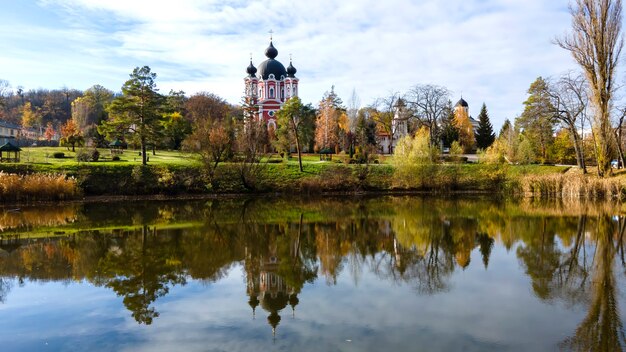 Vista del monasterio de Curchi. La iglesia y un parque. Un lago en primer plano. Moldavia
