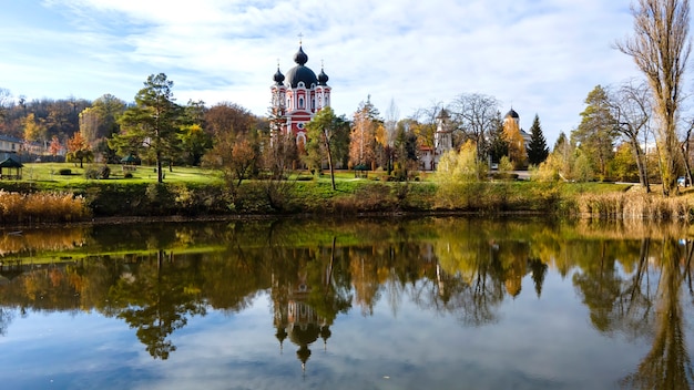 Vista del monasterio de Curchi. La iglesia y un parque. Un lago en primer plano. Moldavia