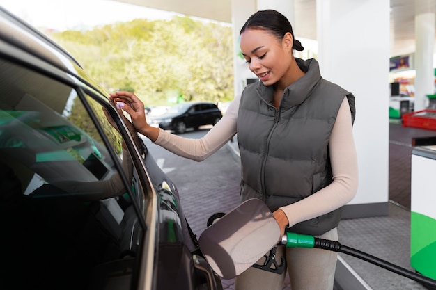 Foto gratuita vista, de, mujer, con, coche, en, el, gasolinera