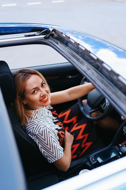 Vista de una mujer conduciendo a través del techo solar