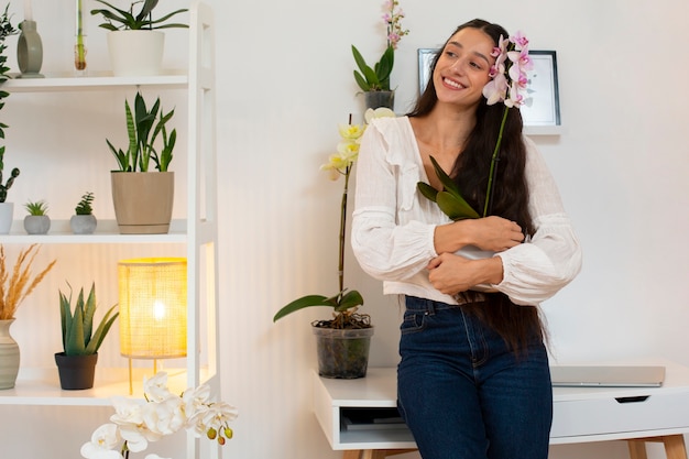 Foto gratuita vista de una mujer decorando su casa con una flor de orquídea