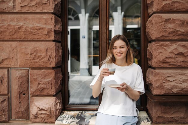 vista, de, mujer joven, tenencia, taza, café, y, sonrisa