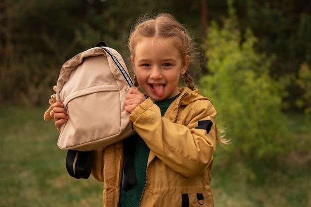 Vista de niña con mochila aventurándose en la naturaleza