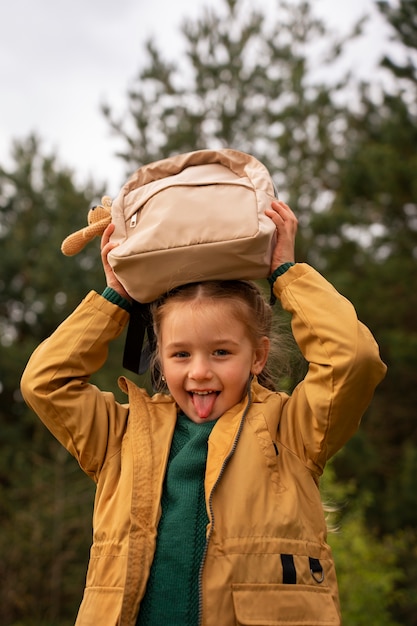 Vista de niña con mochila aventurándose en la naturaleza