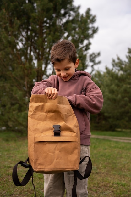 Foto gratuita vista de niño con mochila explorando la naturaleza