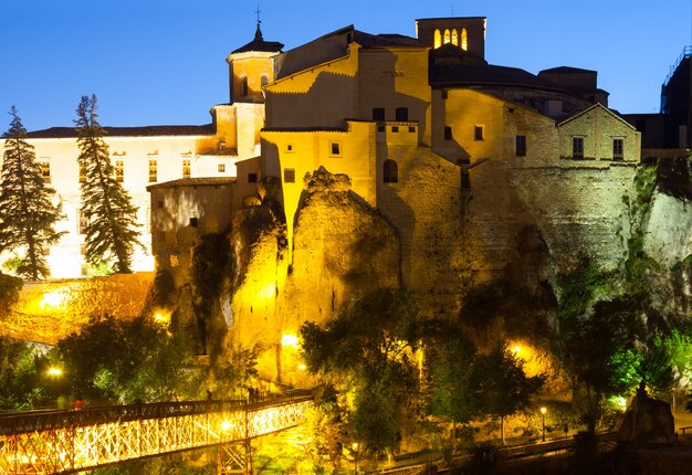 vista nocturna de casas sobre rocas en Cuenca.