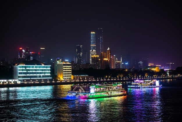 Vista nocturna de la ciudad con barcos en el agua