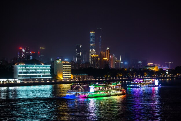 Vista nocturna de la ciudad con barcos en el agua