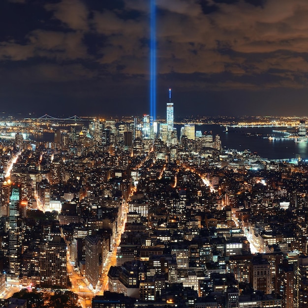 Vista nocturna del horizonte del centro de la ciudad de Nueva York y luz de tributo al 911.