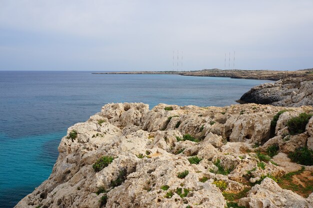 Vista del paisaje de la costa rocosa del océano bajo el cielo azul