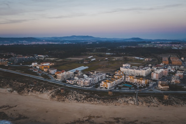 Vista de pájaro de una ciudad con edificios antiguos en la noche con montañas