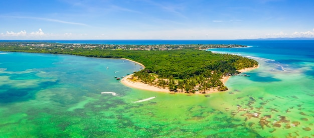 Vista panorámica aérea de la isla tropical bellamente cimentada con frondosos árboles bajo un cielo despejado