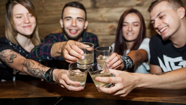 Vista panorámica de amigos tostado vasos de bebida alcohólica