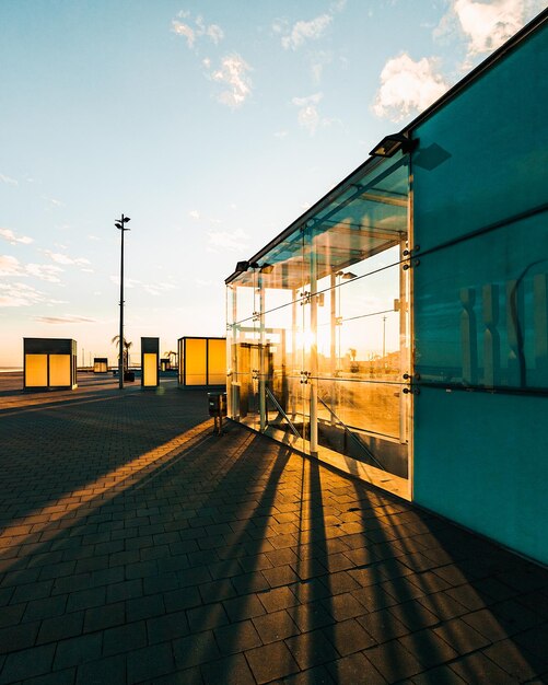 Vista panorámica de un edificio con paredes de cristal con luz solar brillante que pasa durante la puesta de sol