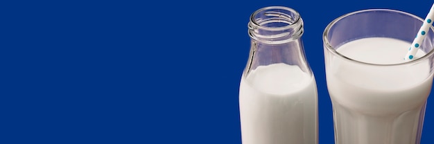 Foto gratuita vista panorámica de la leche en el vaso y la botella sobre fondo azul