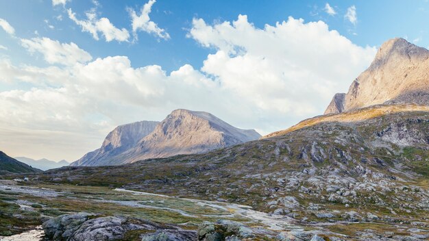 Vista panorámica del paisaje de montañas rocosas con cielo azul y nubes