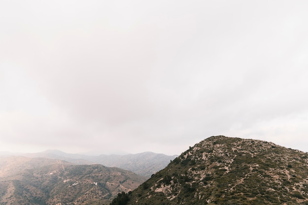 Vista panorámica del paisaje de montañas rocosas con cielo nublado blanco