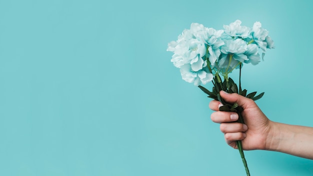 Vista panorámica de una persona con flores artificiales en la mano.