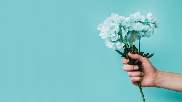 Vista panorámica de una persona con flores artificiales en la mano.