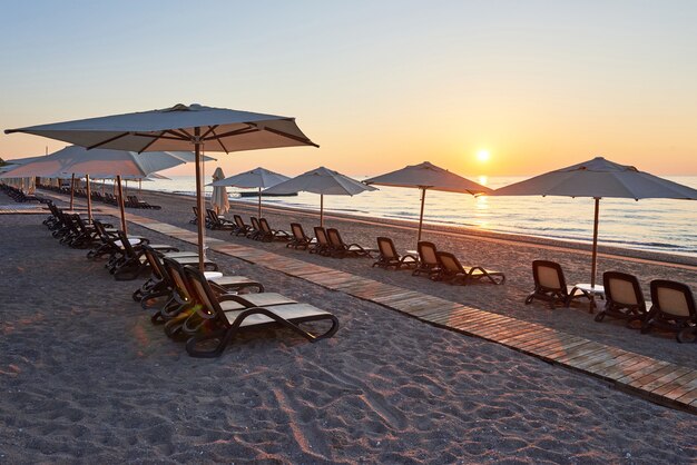 Vista panorámica de la playa de arena en la playa con hamacas y sombrillas abiertas contra el mar y las montañas. Hotel. Recurso. Tekirova-Kemer. pavo