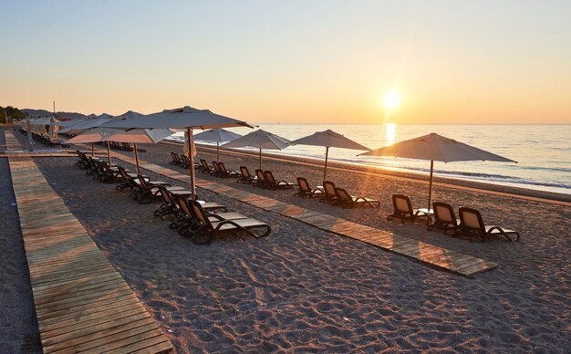 Vista panorámica de la playa de arena en la playa con hamacas y sombrillas abiertas contra el mar y las montañas. Hotel. Recurso. Tekirova-Kemer. pavo