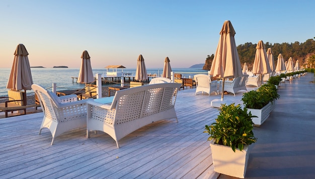 Vista panorámica de la playa de arena en la playa con hamacas y sombrillas abiertas contra el mar y las montañas. Hotel. Recurso. Tekirova-Kemer. pavo