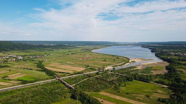 Vista panorámica de un río tranquilo cerca de un pueblo bajo un cielo sombrío