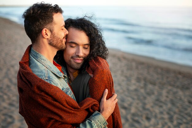 Vista de una pareja gay siendo cariñosa y pasando tiempo juntos en la playa