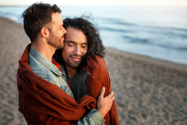 Vista de una pareja gay siendo cariñosa y pasando tiempo juntos en la playa