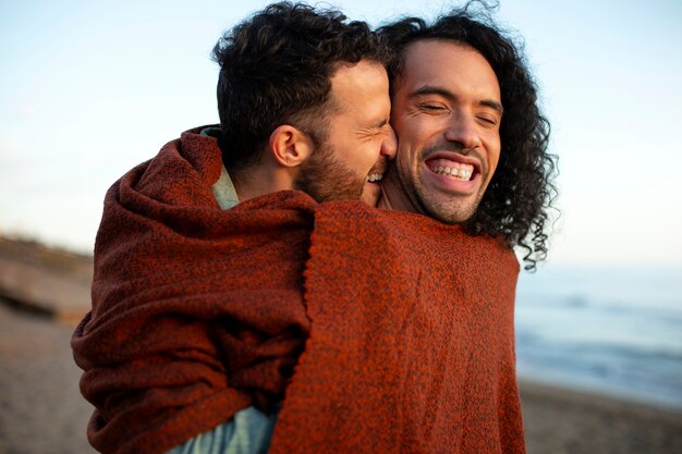 Vista de una pareja gay siendo cariñosa y pasando tiempo juntos en la playa