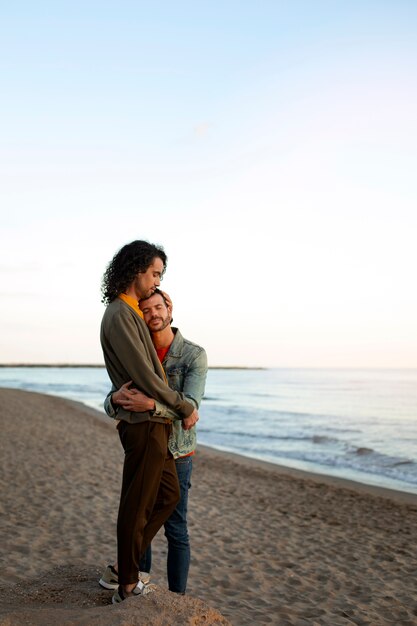 Vista de una pareja gay siendo cariñosa y pasando tiempo juntos en la playa