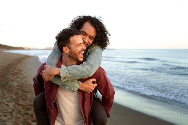 Vista de una pareja gay siendo cariñosa y pasando tiempo juntos en la playa