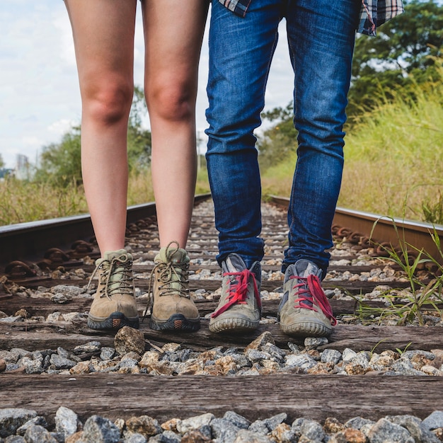 Vista de piernas de pareja joven en vías de tren