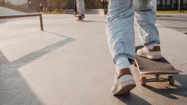 Vista posterior del adolescente con patineta y espacio de copia en el skatepark