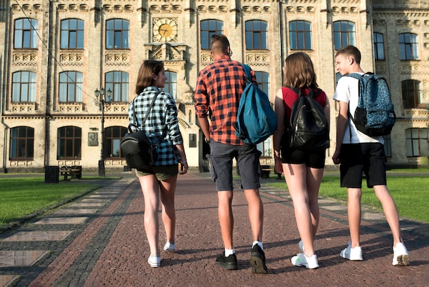 Vista posterior de amigos adolescentes que van a la escuela secundaria