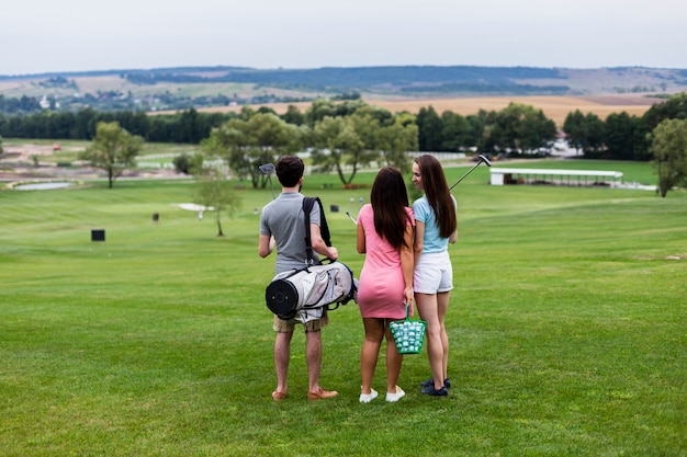 Vista posterior de amigos en el campo de golf.